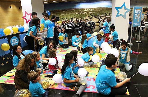 Los niños juegan mientras al fondo se recuerdan los 20 años de FARO. 