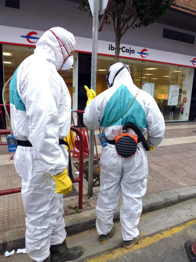 Dos trabajadores del Ayuntamiento de Logroño, que figura en el Registro de Empresas de Riesgo por Amianto, con los equipos de protección mientras manipulan una instalación con amianto. 