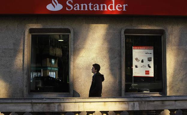 Un joven pasa ante una sucursal del Banco Santander en Madrid. 