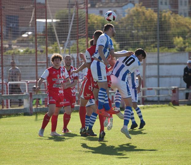 La delantera najerina trata de ganar por alto un balón ante la férrea defensa del Varea.