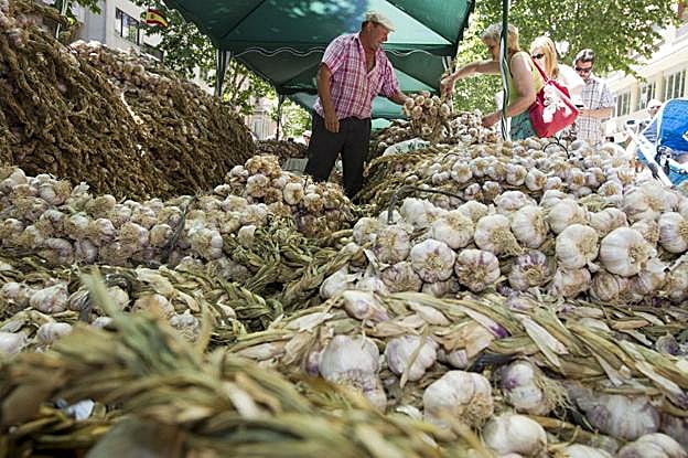 Puesto de venta de ajos en un mercado al aire libre. 