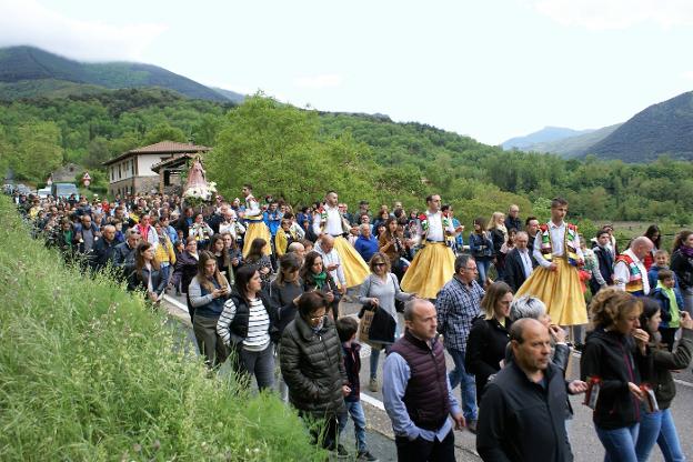 La procesión, abierta por los danzadores, llegando al pueblo.