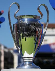 Imagen secundaria 2 - Arriba, los exfutbolistas Morientes y Solozabal y la primera teniente de alcalde en funciones de Madrid, Marta Higueras, posan con la Champions en la Plaza Mayor. En las imágenes inferiores, dos aficionados del Liverpool, junto al trofeo. 