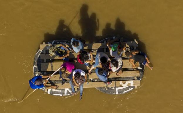 Migrantes tratan de cruzar el río Suchiate en barca hasta Chiapas.