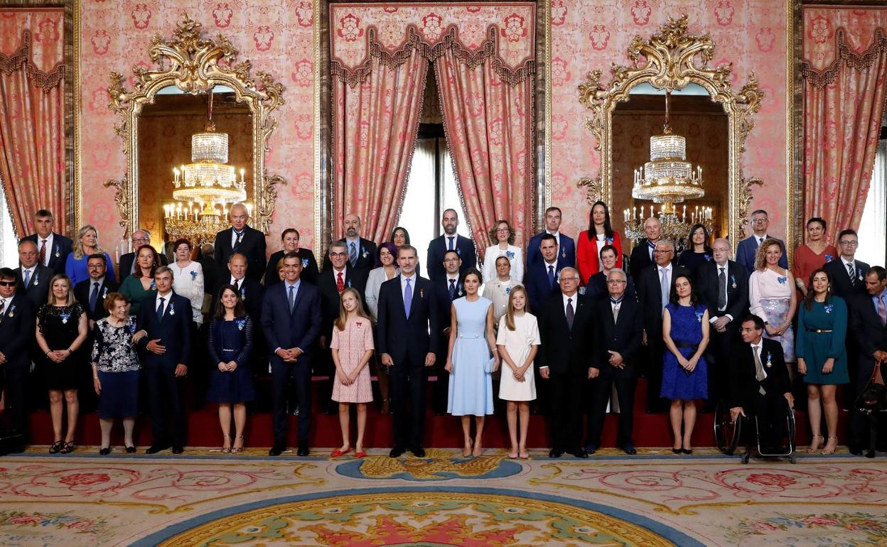 Foto de familia de los Reyes y sus hijas con los galardonados. 