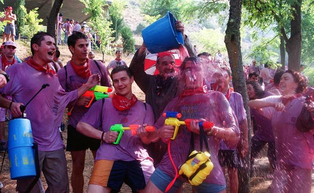 Imagen principal - Jóvenes derramando vino en la «Batalla del Vino» en los Riscos de Bilibio el día de San Pedro, en las Fiestas de San Juan, San Felices y San Pedro de Haro. T.B. | Romería de los hombres de San Millán de la Cogolla a la «Cueva del Santo», donde se cree que vivió San Millán durante 40 años como eremita.,DELPÓN