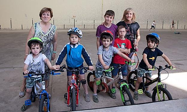 A la derecha, Marisantos Flaño, con sus nietos Daniel y Asier Vázquez, en el frontón de Sorzano, con más amigos y vecinas. 