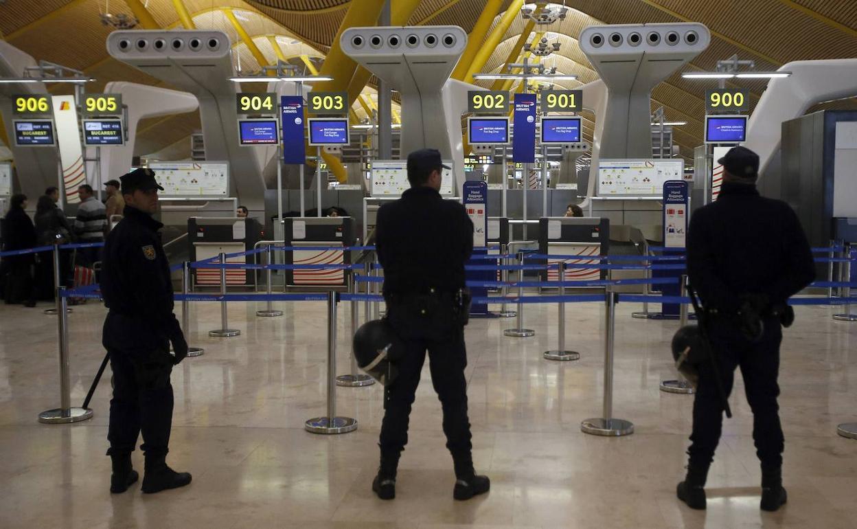 Policías antidisturbio vigilan la T4 de Barajas durante una huelga de trabajadores.