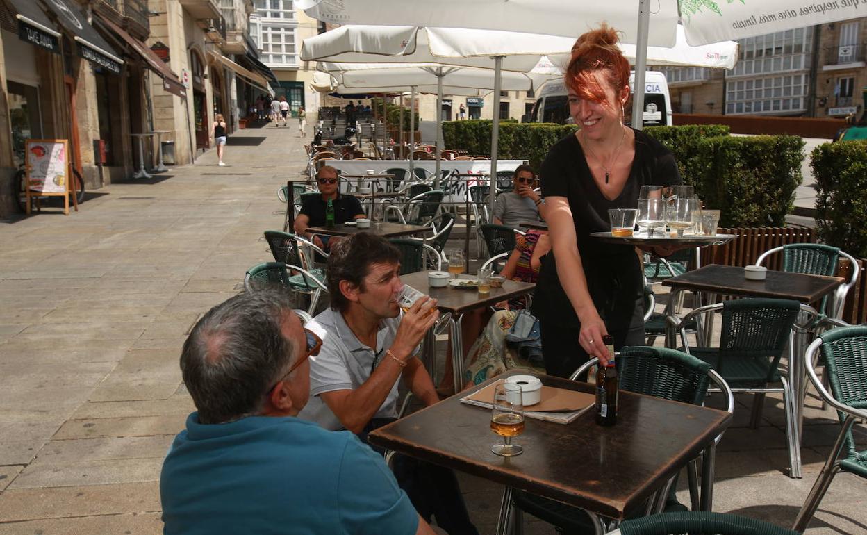 Una camarera sirve en una terraza.