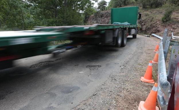 Un camión de gran tonelaje pasa por un puente del embalse. 