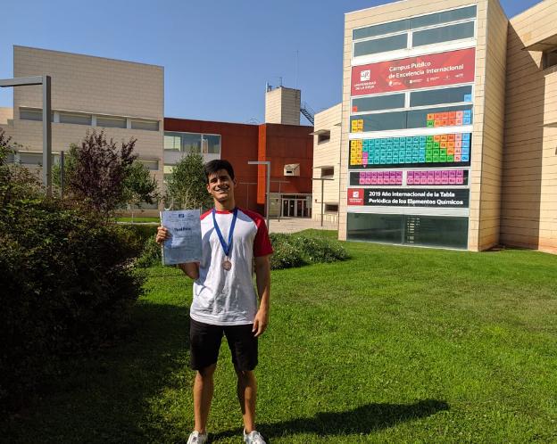 Alejandro Mahíllo delante del campus de matemáticas de la UR con su bronce. 