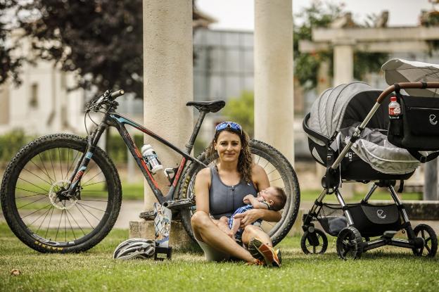 María Gómez Ijalba posa con su hijo Aleix, su trofeo, su bicicleta y su carro de niño en un parque de Fuenmayor, donde reside. 