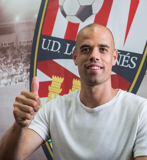 Rubén Miño levanta su pulgar con el escudo de la UD Logroñés a su espalda. 