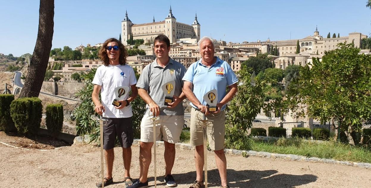 Iván Ayala, en el centro de la imagen, posa con su trofeo con el Alcázar de Toledo al fondo.