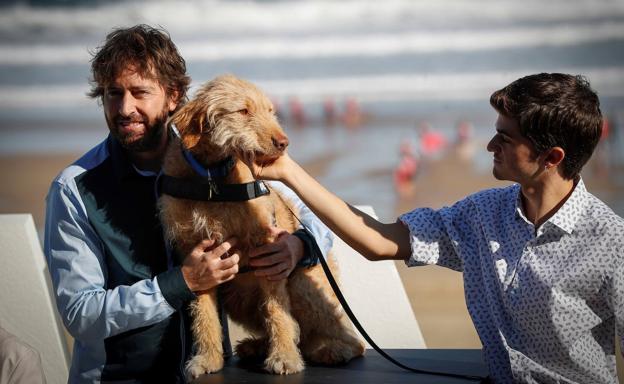 El director Daniel Sánchez Arévalo y el actor de 'Diecisiete' Biel Montero posan junto a Oveja, el perro del filme, en San Sebastián.