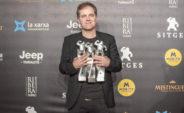 El director bilbaíno Galder Gaztelu-Urrutia con tres de los cuatro galardones obtenidos por 'El Hoyo' en el Festival de Sitges.