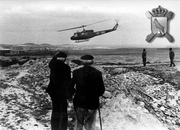 Dos hombres observan un helicóptero en maniobras en El Villar de Arnedo (1984). 