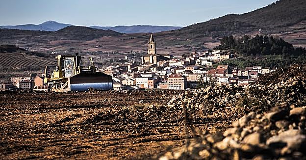 Una máquina trabajaba ayer moviendo tierra en las obras de la Ronda Sur de Logroño, con Navarrete al fondo. 