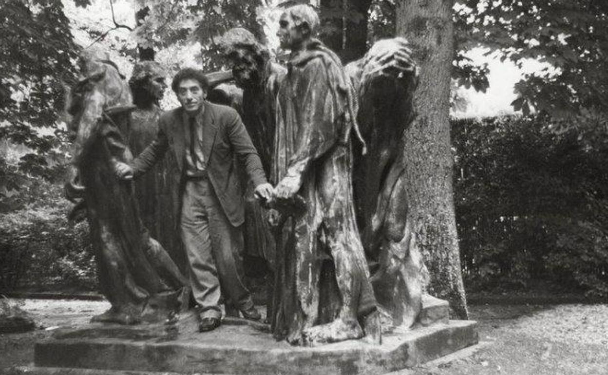 Alberto Giacometti posando en 1950 ante 'Los burgueses de Calais', la gran obra de Rodín, en un parque de Vésinet.