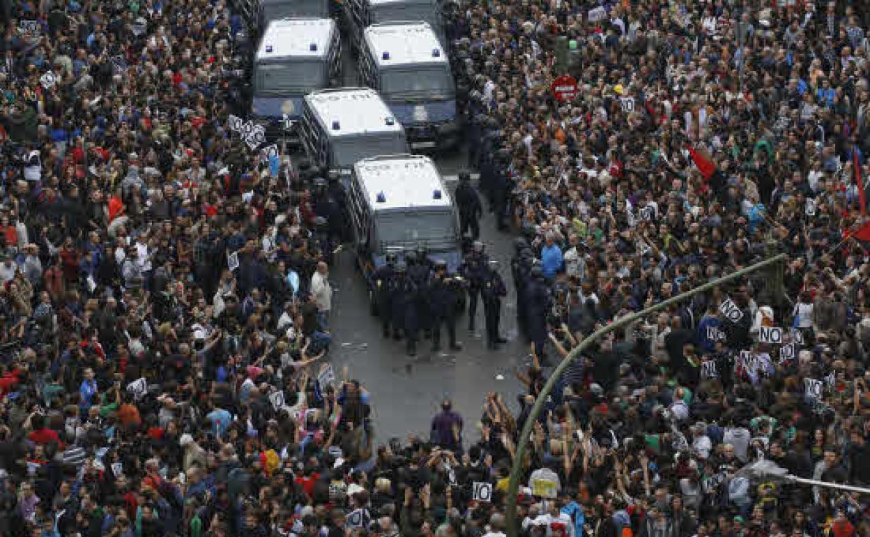 Manifestantes rodean a una furgoneta de la Policía Nacional durante una manifestación de protesta en las inmediaciones del Congreso de los Diputados 