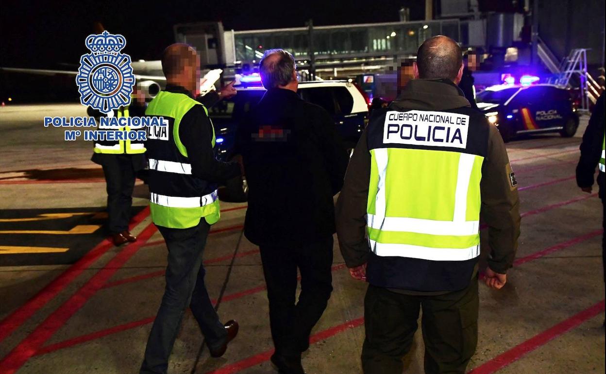 García Juliá, escoltado por dos policías tras aterrizar este viernes en el aeropuerto de Barajas procedente de Brasil.