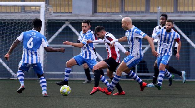 Emilio intenta zafarse de la presión de cuatro futbolistas de la Oyonesa. La presión local fue la tónica del partido. 