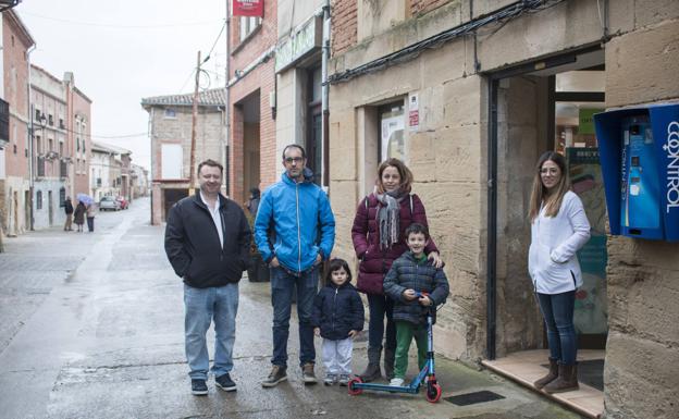 Un grupo de personas psoa junto a al farmacia de la localidad.