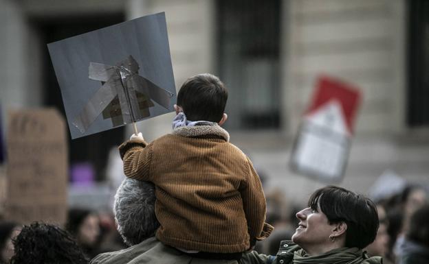 Un niño porta su popia pancarta.