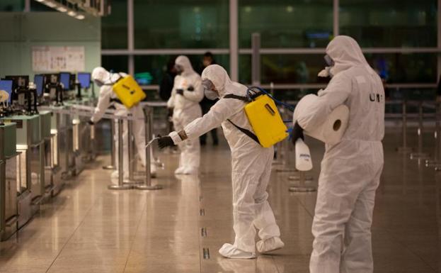 Militares del UME limpian el suelo durante las tareas de desinfección en el Aeropuerto de El Prat.