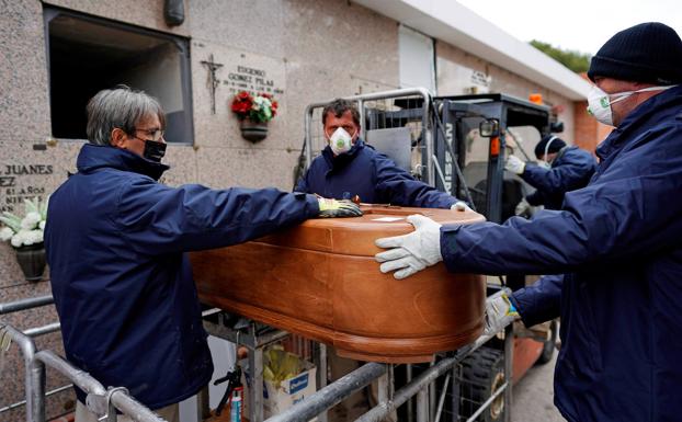 Trabajadores funerarios en el cementerio de Carabanchel.