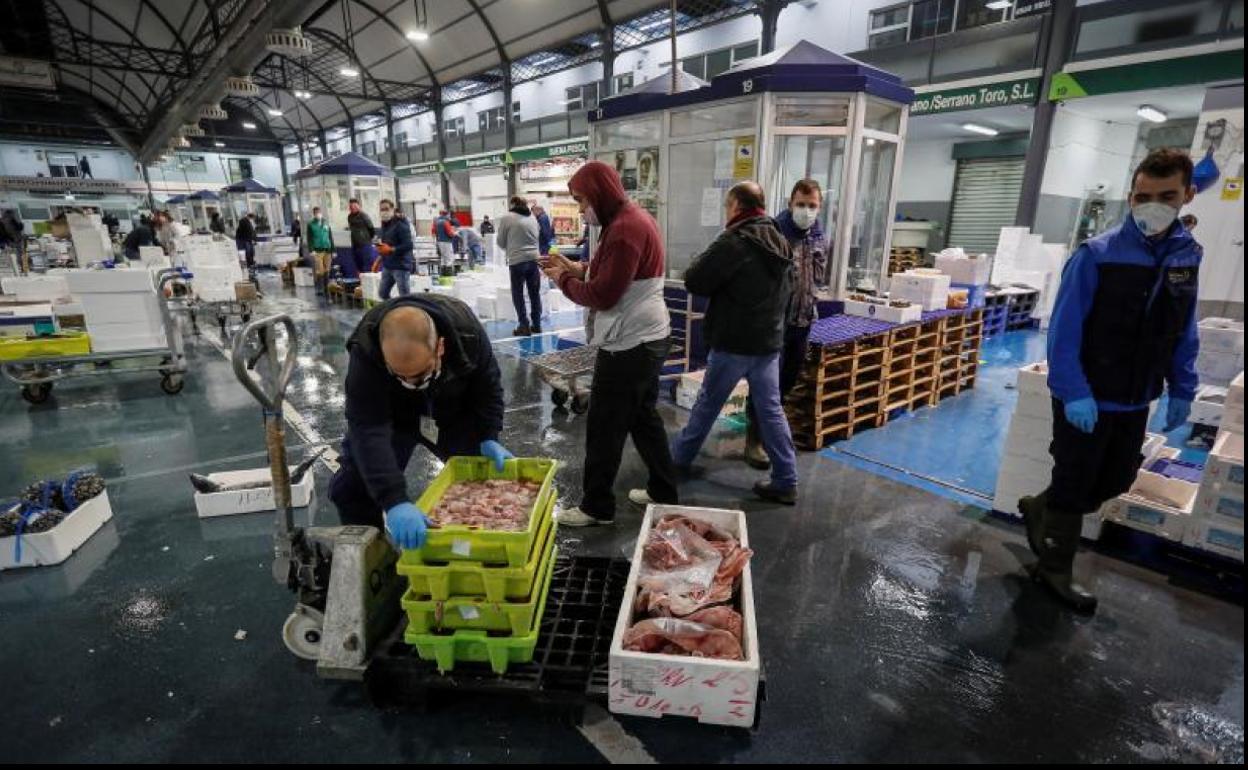 Minoristas cargando mercancía en una de las naves de venta de pescado en Mercasevilla.