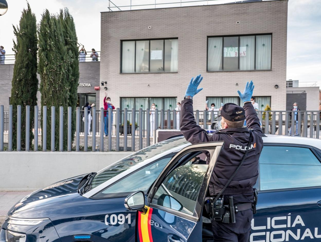 Un agente del Cuerpo Nacional de Policia saluda a los trabajadores de la residencia Montesoria de Logroño. 