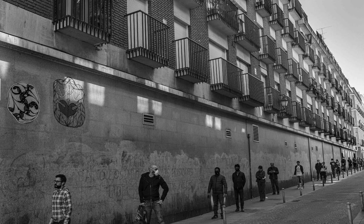 Personas haciendo cola y guardando la distancia de seguridad. 