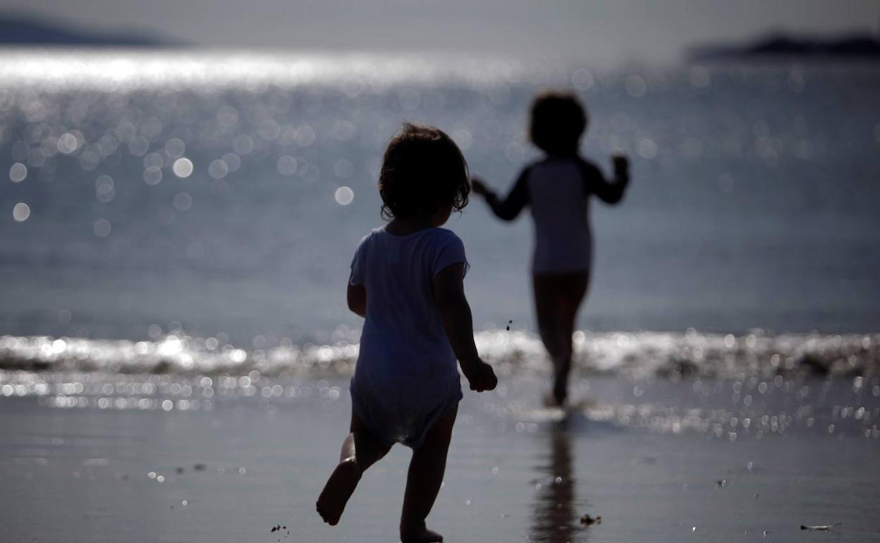 Unos niños juegan en la playa.