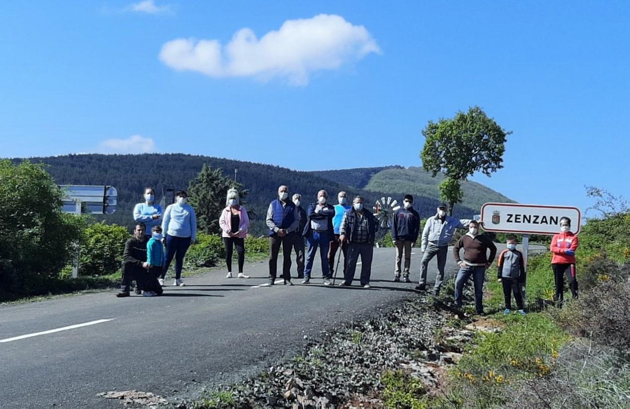 Los vecinos de la aldea de Zenzano, ayer, a pie de la carretera de acceso. 