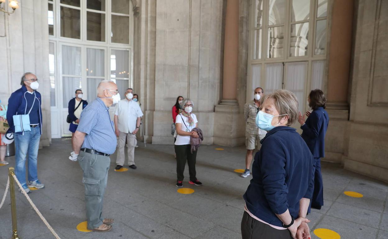 Varias personas visitan el interior del Palacio Real. 