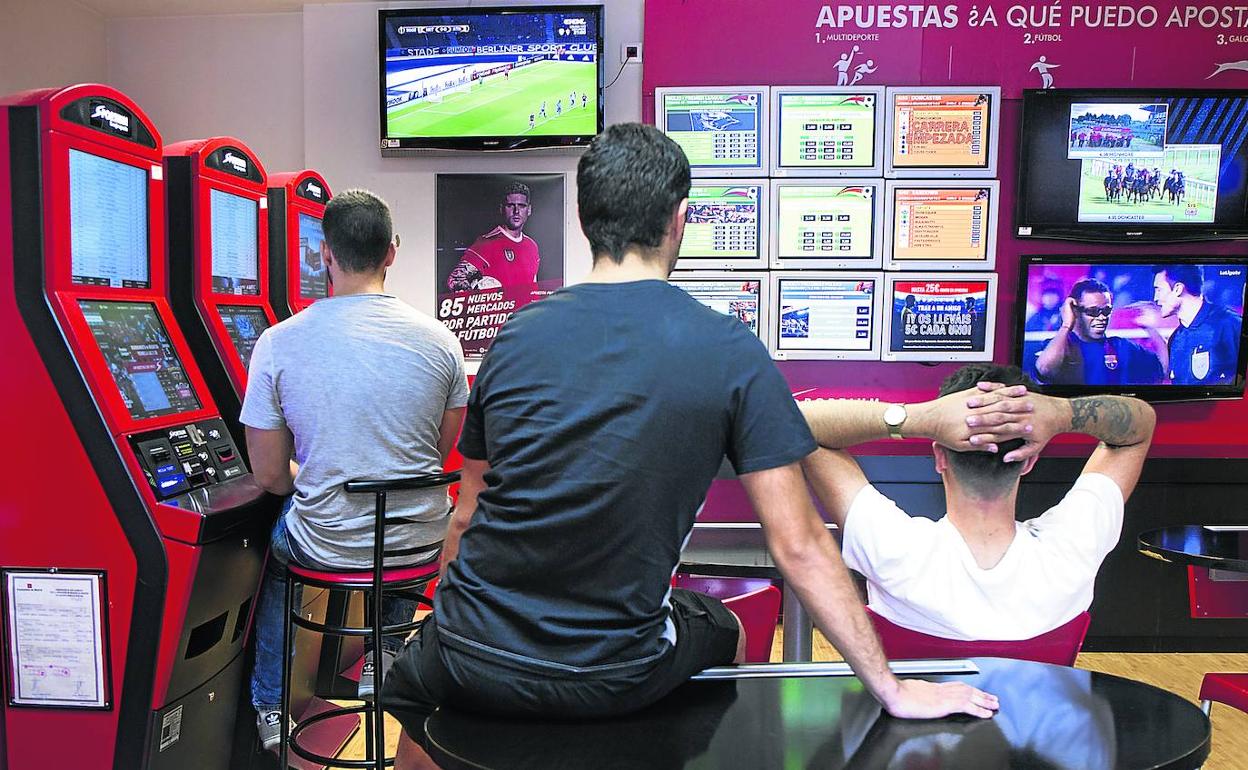 Jóvenes pasan su tiempo en una casa de apuestas de la Comunidad de Madrid.