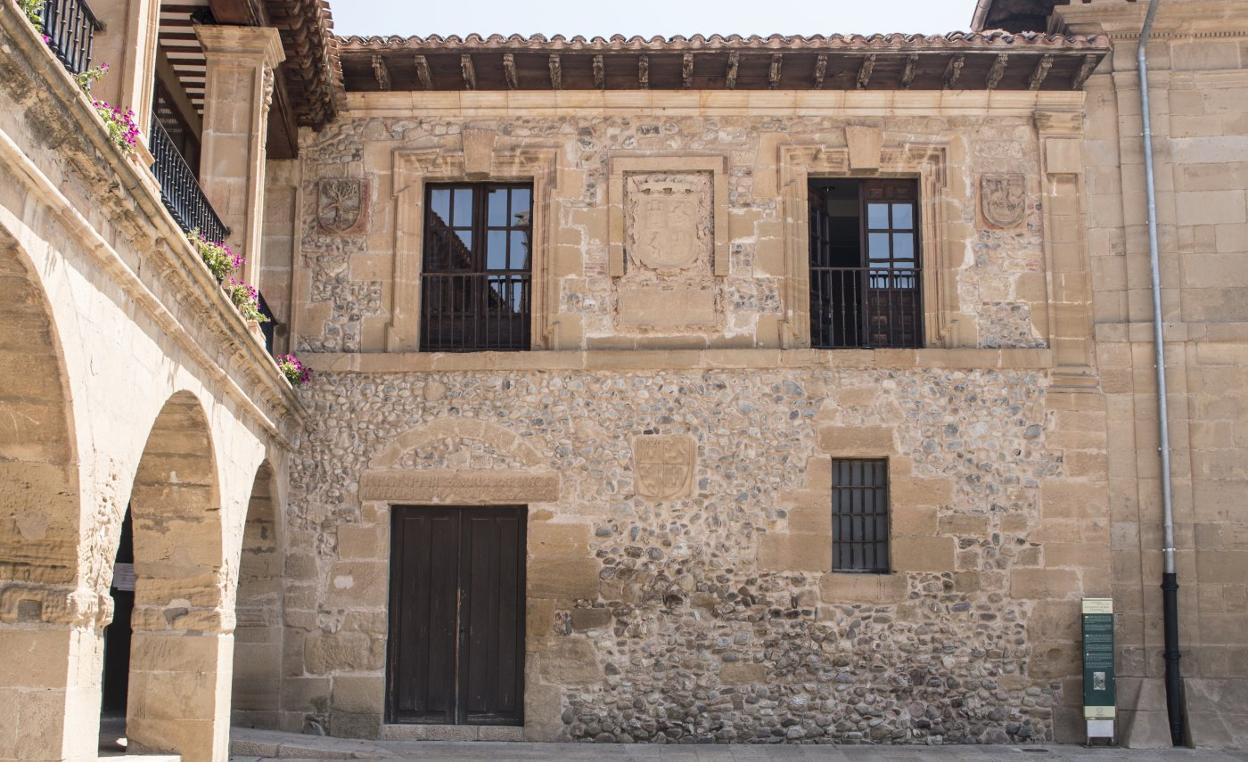 La fachada contiene escudos e inscripciones del anterior edificio y un escudo real en el centro. 