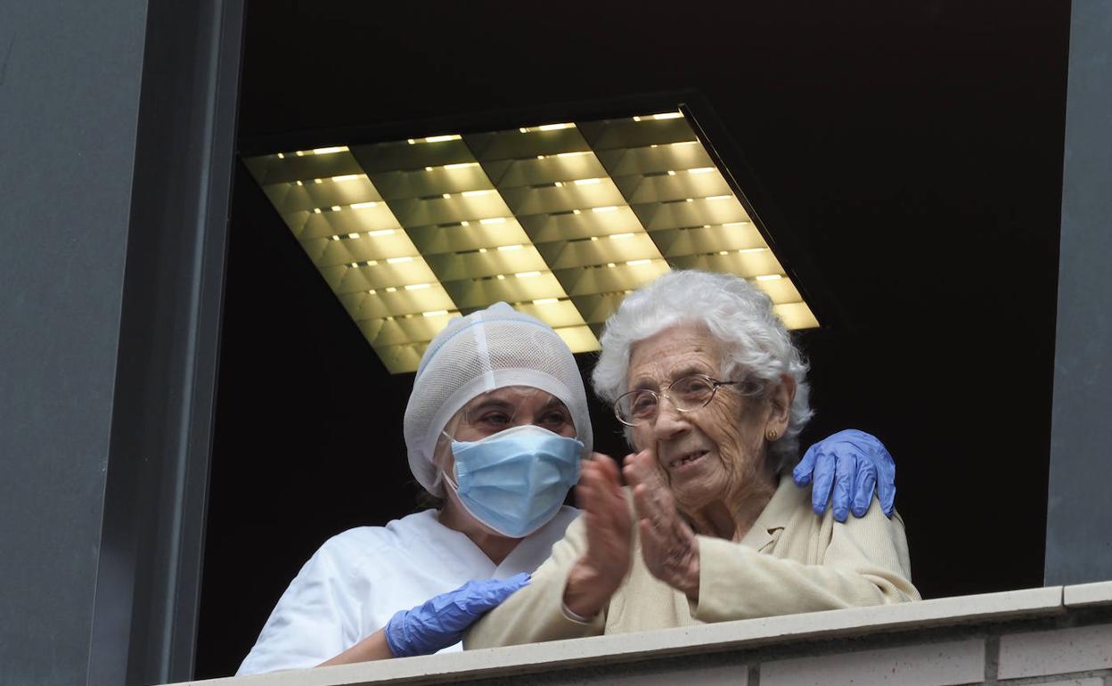 Una trabajadora y una residente, en un centro de mayores de Gijón.