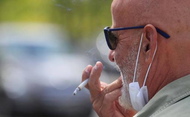 Un hombre fuma en la vía pública en Madrid.