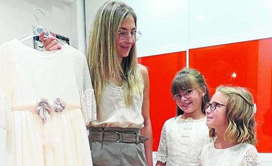 Daniela, con su hermana, su madre y sus dos vestidos de comunión. 