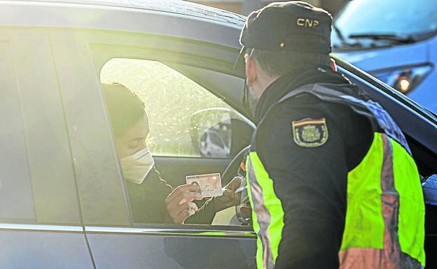 Una mujer muestra su dni al agente. 