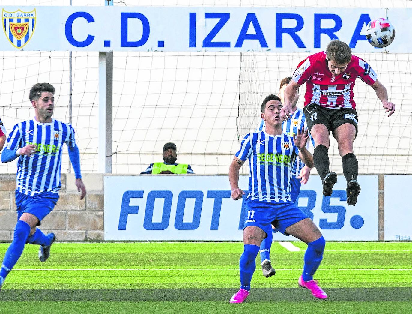 Javito despeja el balón de cabeza anticipándose a un jugador local.