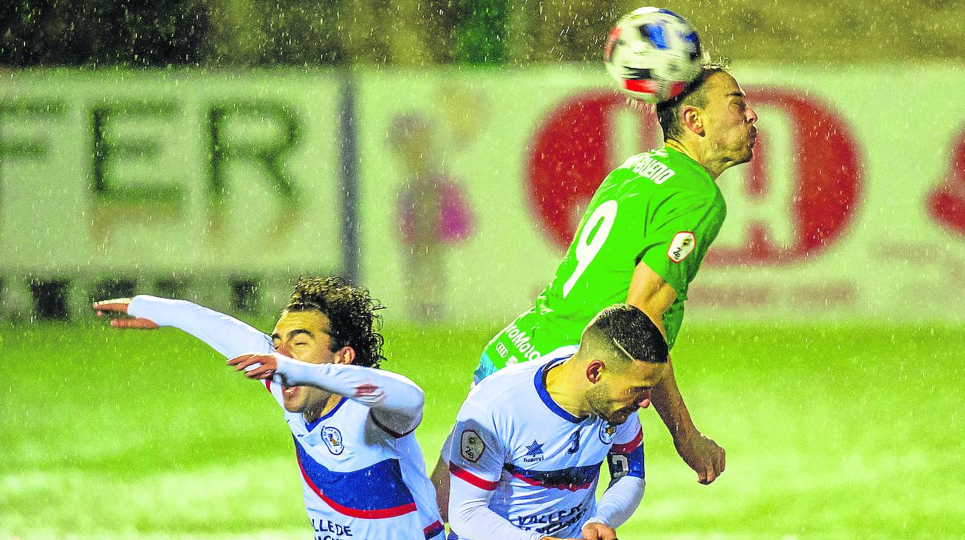 Mikel Bueno se eleva por encima de dos defensas. 