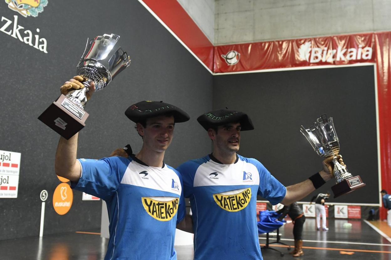 Martija y Ezkurdia levantan sus trofeos y lucen sus txapelas de campeones del Parejas tras la final de ayer. 