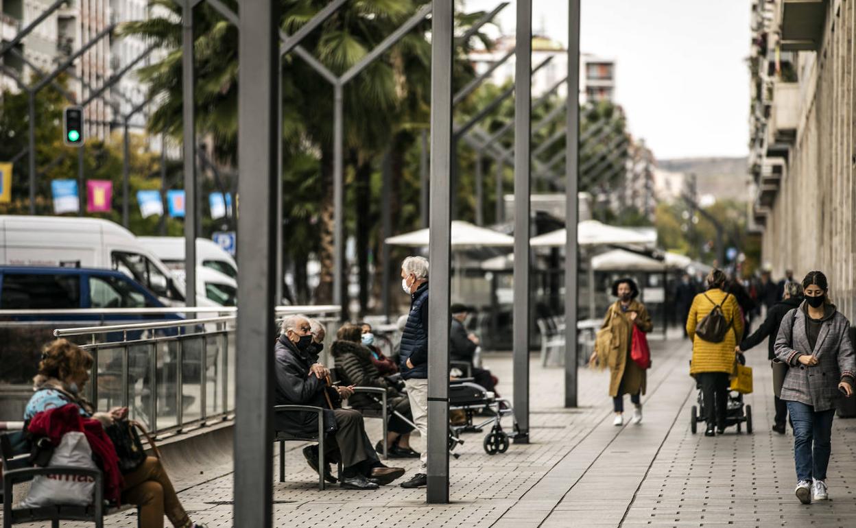 Gente descansando en bancos y viandantes en la Gran Vía logroñesa. 