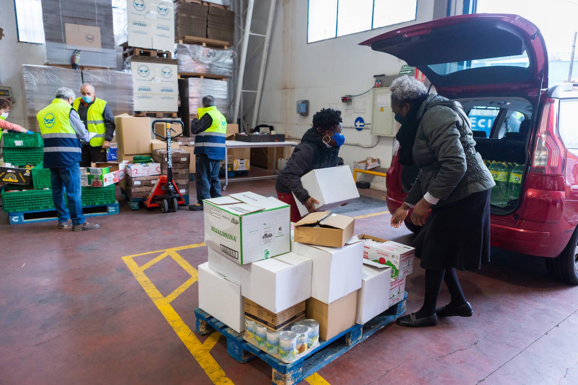 Dos mujeres acuden con su coche al centro logístico del Banco de Alimentos. 