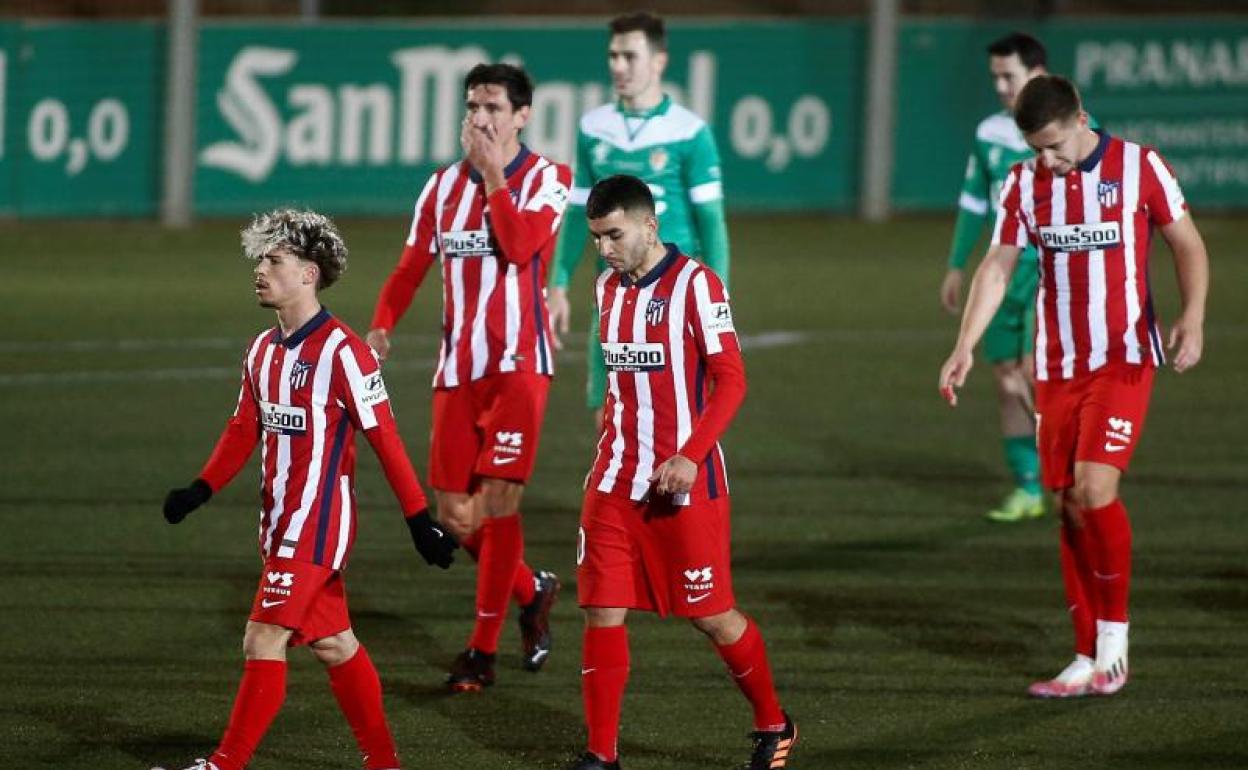 Los jugadores del Atlético se retiran derrotados del terreno de juego del Cornellà. 