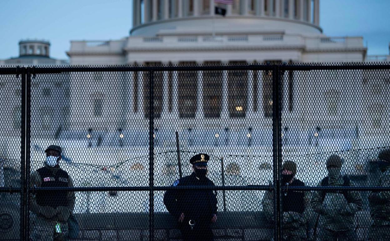 Un agente de la Policía del Capitolio junto a miembros de la Guardia Nacional ayer jueves