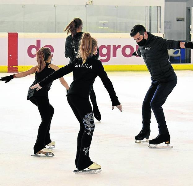 Dos patinadoras siguiendo las lecciones del bicampeón.